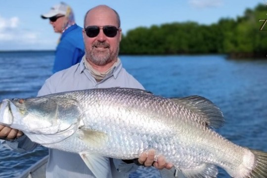 a man holding a fish swimming under water