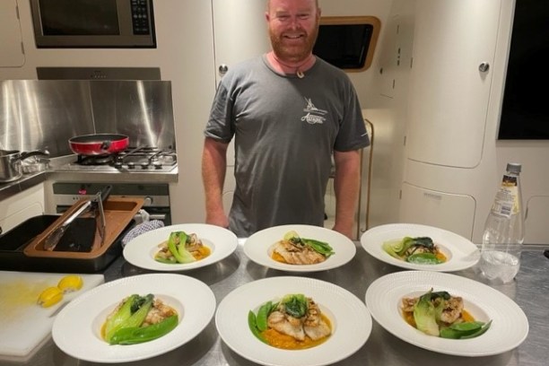 a man sitting at a table with a plate of food
