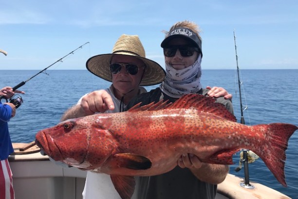 a man holding a fish in the water